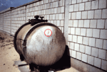 Photographs of the storage tank at the Kuwaiti Girls' School taken by the safety officer in August 1991.&nbsp; Encircled areas show the movement of the fumes out of one of the bullet holes.&nbsp;(Photographs used by permission.)